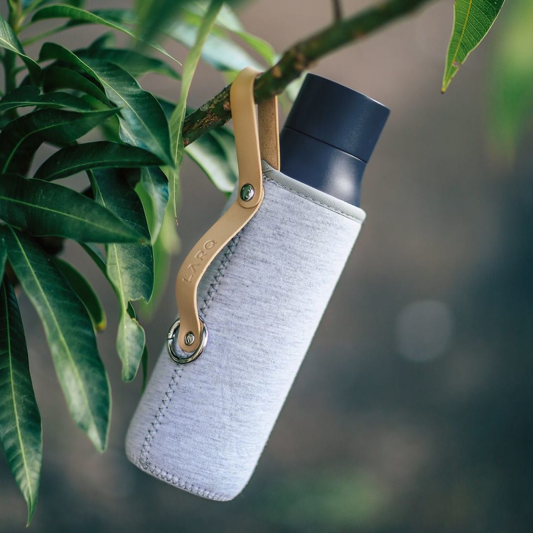 Photo of LARQ Bottle PureVis&trade; - Monaco Blue in Travel Sleeve hanging on a tree