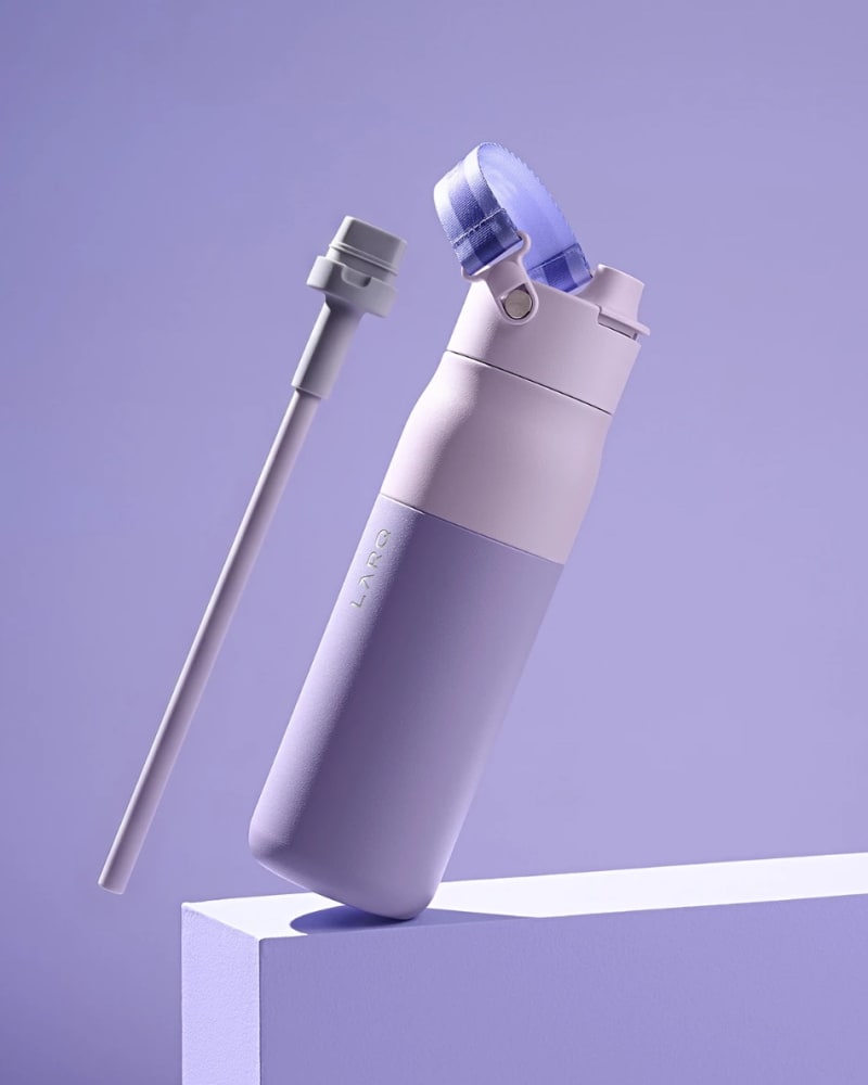 LARQ Bottle Swig Top in florence by mills purple, tilted on a plinth beside its detachable straw