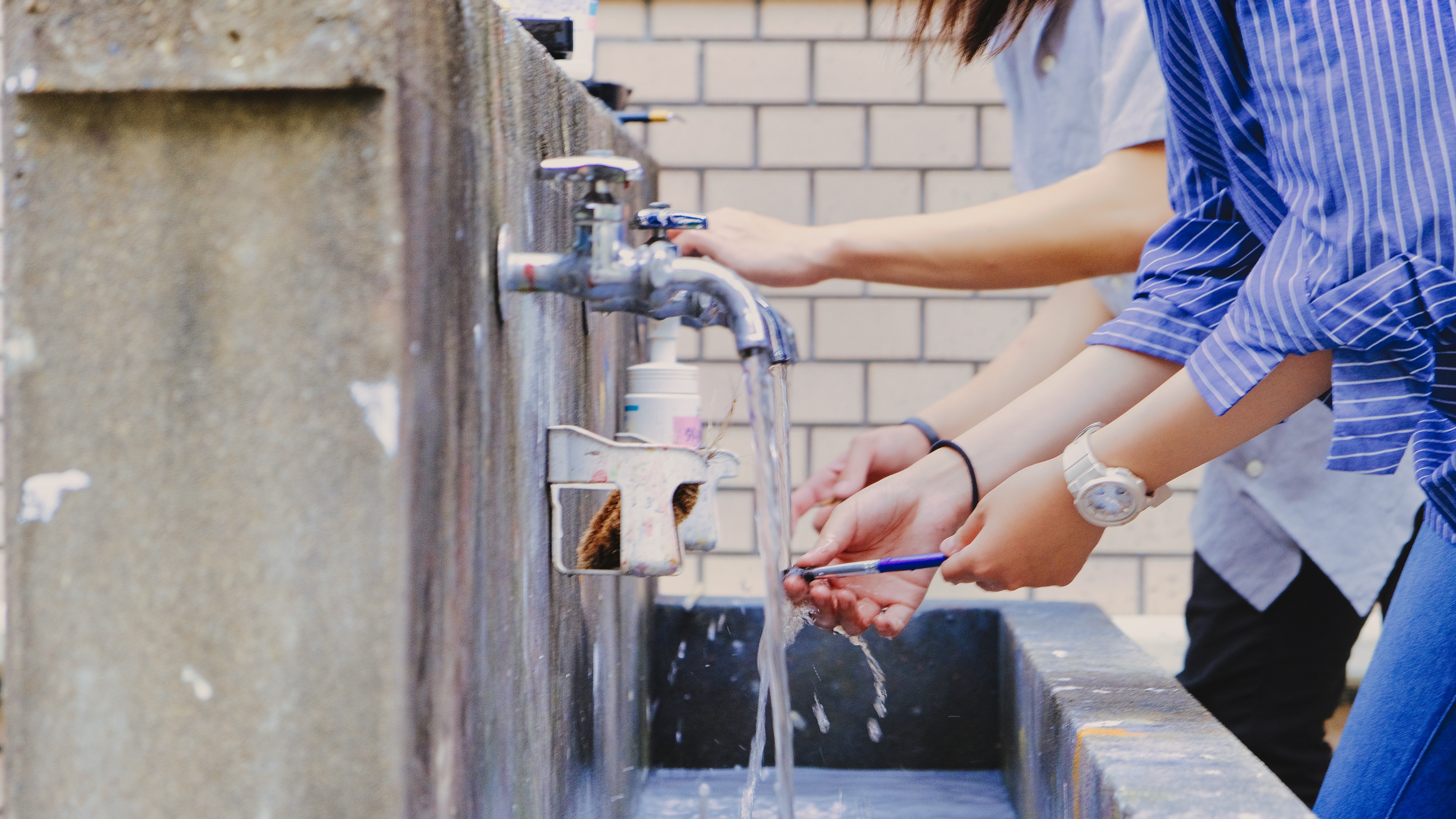 People wash their hands under the tap