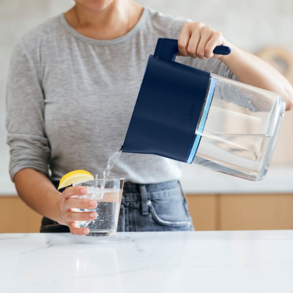 Photo of Larq Pitcher PureVis&trade; - Monaco Blue pouring water in glass (wide shot)